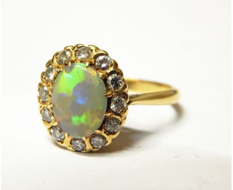 Gold, opal and diamond cluster ring, the central oval opal surrounded by 12 eight-cut diamonds, marked 18ct, finger size 'V' 