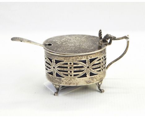 Silver mustard pot, Chester 1914 of oval form with pierced sides, the hinged cover with shell thumbpiece on four bracket feet