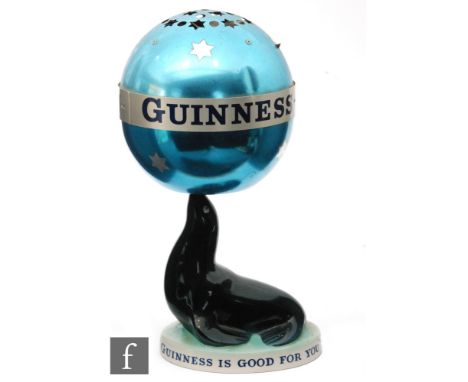 Carlton Ware  - A Guinness advertising lamp modelled as a black sea lion holding a globe shade, banded 'Guinness is good for 