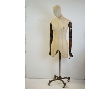 Female Shop Mannequin with articulated wooden arms, cloth body and raised on a metal industrial style base, 146cms high 