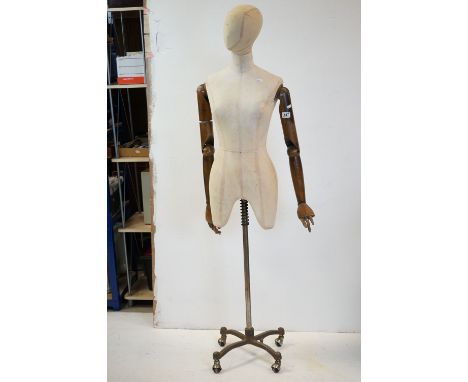 Female Shop Mannequin with articulated wooden arms, cloth body and raised on a metal industrial style base, 164cms high 