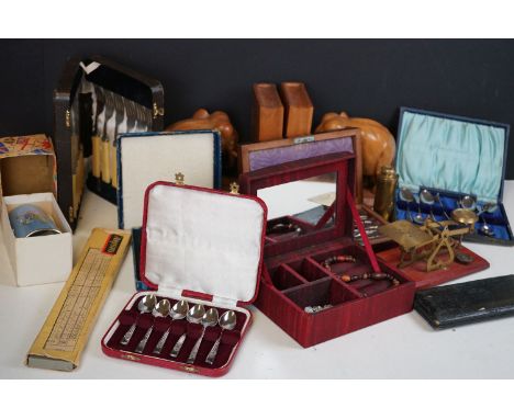 A box of mixed collectables to include wooden elephant book ends, vintage drawing sets, cased silver plated cutlery and a set