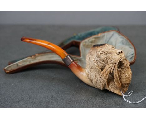 A large oversized finely carved meerschaum pipe in the form of a hunting dog, with amber mouthpiece and white metal collar. 