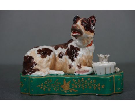 19th century ceramic inkwell and pen stand in the form of a recumbent dog on a plinth 