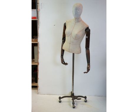 Female Shop Mannequin with articulated wooden arms, cloth body and raised on a metal industrial style base, 151cms high 