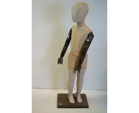 Child Shop Mannequin with articulated wooden arms, cloth body and stood on a wooden base, 113cms high 