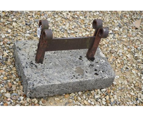 A vintage wrought iron boot scraper set into a stone block. 