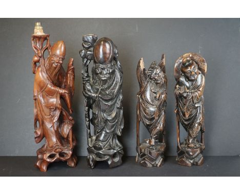 A collection of four oriental wooden carved figures to include two used as lamp bases. 