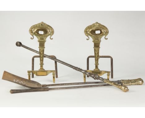 PAIR OF GILT BRASS FIRE DOGS, each with bell flower cast tapering column surmounted by an embossed oval and raised on square,