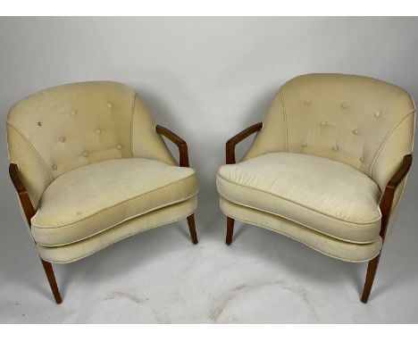 A pair of 1950's vintage teak lounge chairs
Upholstered and buttoned in cream, the curved backs above show wood arms and padd