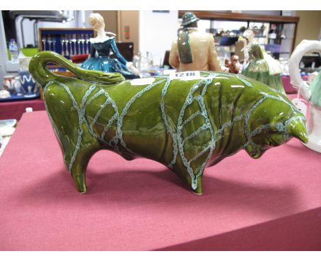 A 1960's Trentham Art Ware Bull, designed by Colin Melbourne, in green glaze with trailed linear decoration.