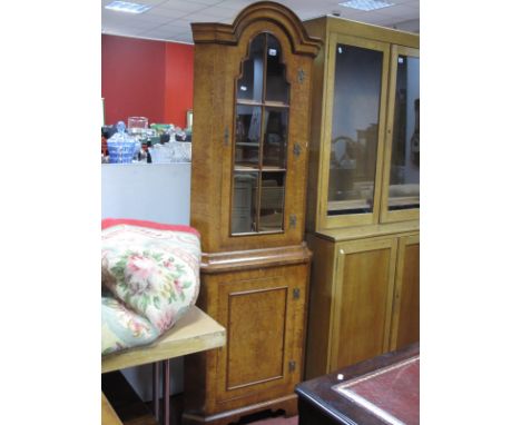 A Walnut Double Corner Cupboard, with arched top and glazed door over panelled cupboard door, on bracket feet.