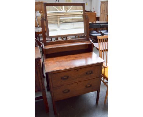 An oak dressing table with tilting mirror above shelf and two long drawers