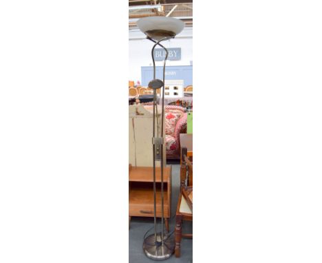 A polished brass floor standing uplighter with adjustable reading lamp