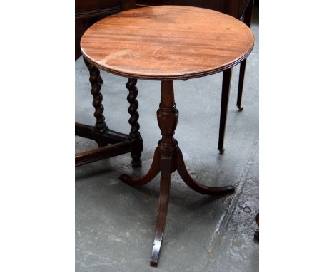 A small mahogany tripod table, the circular tip-top on a carved column supported sabre legs
