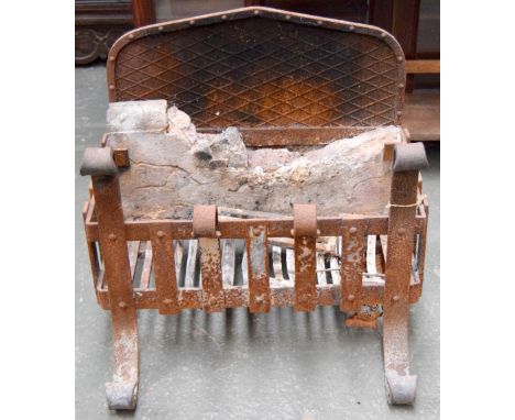 A large iron fire grate and back, the front legs scrolling at top and bottom