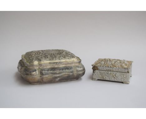A chased white metal trinket box, foliate design to top and intricate pattern to base, 19x17x8cmH, with a smaller metal trink