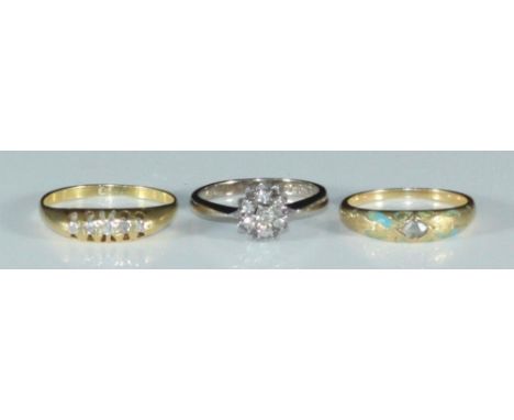 An 18ct white gold diamond cluster ring, 18ct five-stone ring, and an unmarked yellow metal, diamond and enamel ring (testing