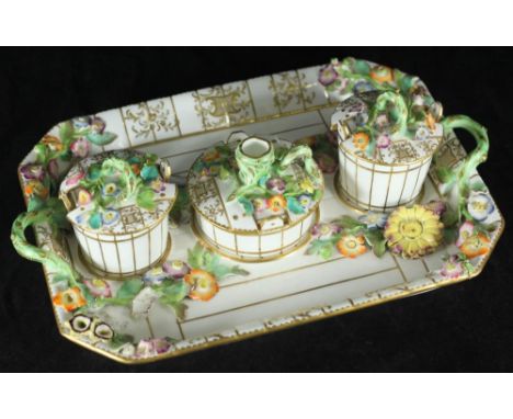 A 19th century floral encrusted porcelain ink-stand, of rectangular form with three simulated wooden pails, decorated with po