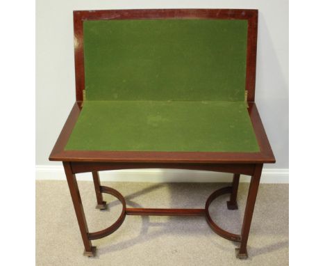 An early 20th century mahogany folding card table of rectangular form, on square supports and castors with shaped stretcher, 