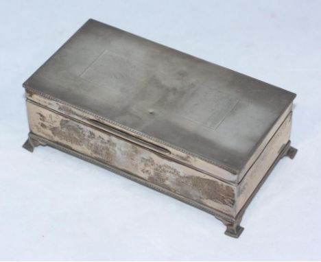 A silver table-top cigarette box, of rectangular form, blank inscription panel to the engine-turned hinged cover, cedar linin