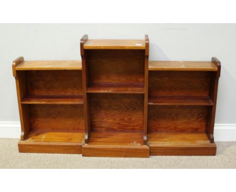 A stained mahogany breakfront bookcase, the raised central section with single shelf, flanked by two further sets of shelves 