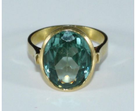 An 18ct gold ring set with a large oval faceted topaz 'coloured' gemstone, measuring 15.13x11.43mm, 7.34 grams gross 