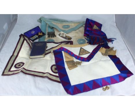 A quantity of Masonic jewels including a silver jewel, three aprons, a sash and a book on the Complete Workings of Craft Free