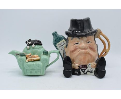 A Staffordshire Fine Ceramics teapot of a man together with a Swineside ceramics teapot of a cat on a sofa (2). Both in good 