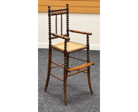 A LATE NINETEENTH CENTURY MAHOGANY CHILD'S HIGH-CHAIR having a footrest and bobbin supports and with cane work seat, possibly