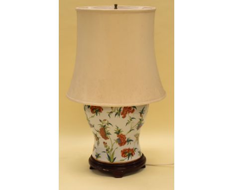 AN ORIENTAL STYLE CERAMIC TABLE LAMP decorated with colourful flowers and insects on white ground, with shade, 77cms high