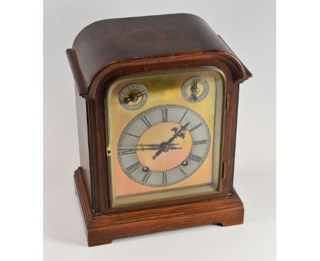 A GERMAN MANTEL CLOCK having a domed brass dial with silvered chapter ring bearing Roman numerals and with chime and with two