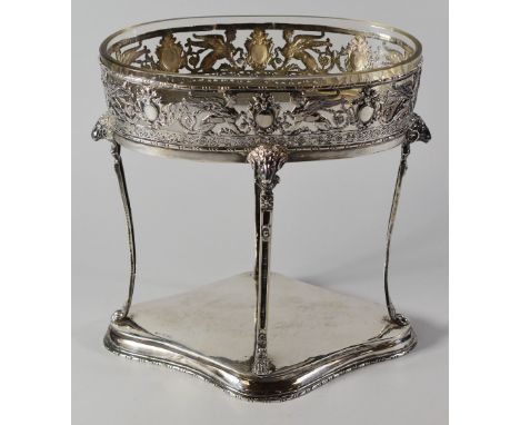 A CONTINENTAL SILVER TABLE CENTREPIECE raised on four bow supports with goat-head and hoof terminals, decorated with open and