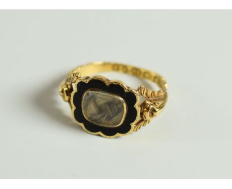 A VICTORIAN 18CT YELLOW GOLD MOURNING RING having a black enamel framed locket of hair, 3.35gms