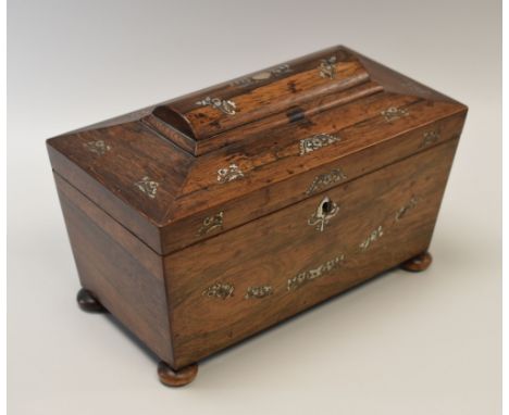 A MOTHER-OF-PEARL INLAID ROSEWOOD TEA-CADDY of sarcophagus form on bun feet, the interior divided into three compartments and