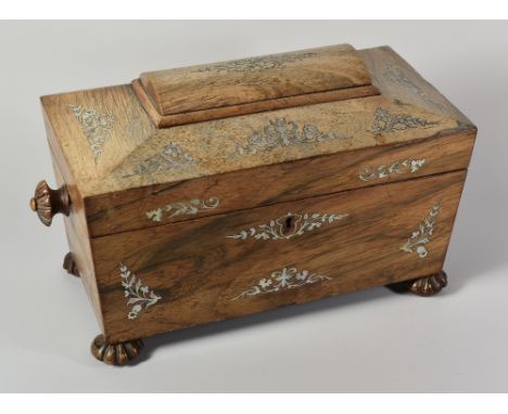 A GEORGIAN ROSEWOOD TEA-CADDY of sarcophagus form and having mother-of-pearl floral decoration, raised on four fluted bun fee