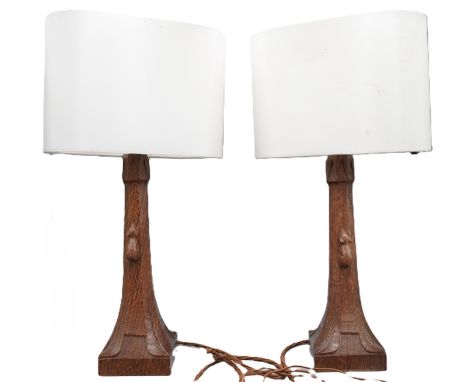 Robert Mouseman Thompson of Kilburn - pair of oak table lamps, tapered octagonal columns on square bases, carved with signatu