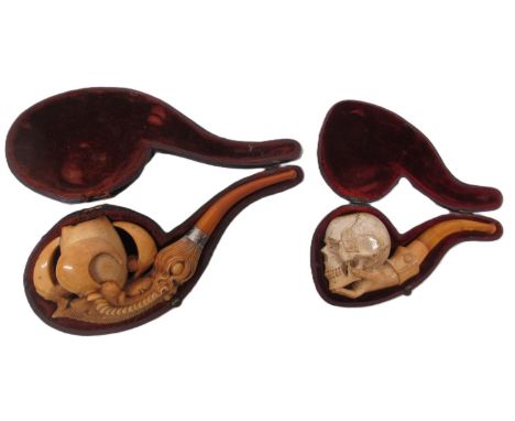 19th Century meerschaum pipe, bowl carved in the form of a human skull supported by a hand, amber mouth piece L13cm; another 