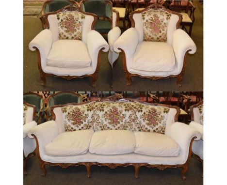 A reproduction Louis XV style walnut framed three-piece suite, upholstered in floral and cream fabric, comprising a three-sea