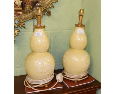 A pair of Chinese porcelain double gourd vases, decorated with prunus on a lemon yellow ground, mounted as table lamps (2)