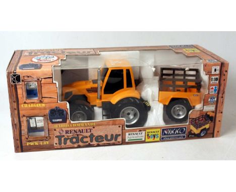 A Nikko radio controlled 27MHZ 1/18 scale Renault tractor and farm trailer, appears as issued, housed in the original window 