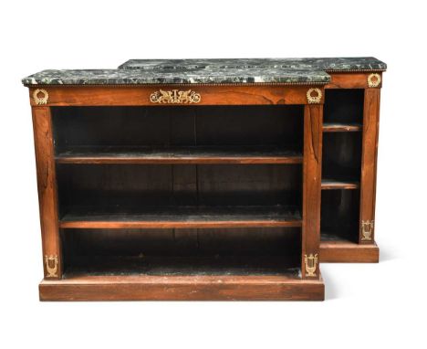 A pair of Empire rosewood and ormolu mounted open bookcases, circa 1825, with rectangular green marble tops and confronting w