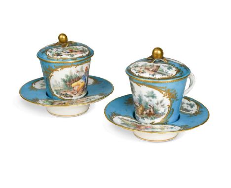 A pair of Sèvres style trembleuse chocolate cups, covers and saucers, the bleu-celeste ground bodies reserved with shaped pan