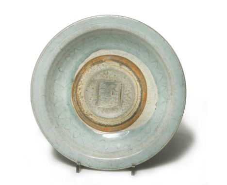 A Chinese Provincial porcelain bowl, 17th century,  with light blue glaze, centrally with an impressed seal mark, within wave