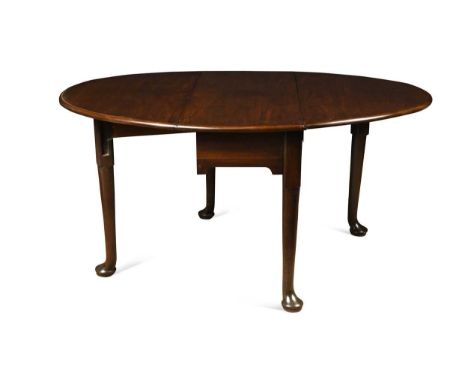An early George III Cuban mahogany dining table, the oval top with hinged flaps supported by gate legs tapering to generous p