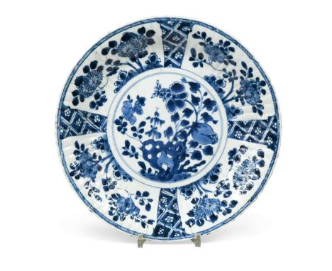 A Chinese blue and white porcelain shallow fluted dish,  Kangxi (1662-1722), with central panel of rock work and shrubs  27cm