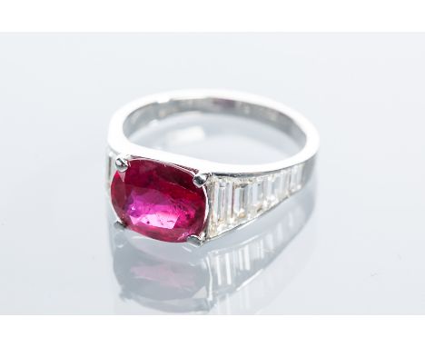 IMPRESSIVE RUBY AND DIAMOND CLUSTER RING
the central oval brilliant cut ruby of approximately 2.85 carats, on channel set bag