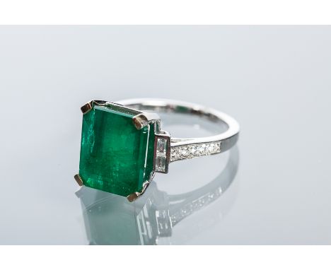 EMERALD AND DIAMOND RING
the central step cut emerald approximately 6.70 carats, flanked by baguette cut diamonds and on diam