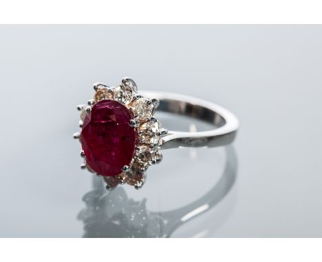 RUBY AND DIAMOND CLUSTER RING
the central oval cut ruby approximately 3.03 carats, surrounded by brilliant cut diamonds total