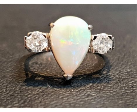 OPAL AND DIAMOND THREE STONE RINGthe central pear cabochon opal flanked by round cut diamonds totaling approximately 0.5cts, 